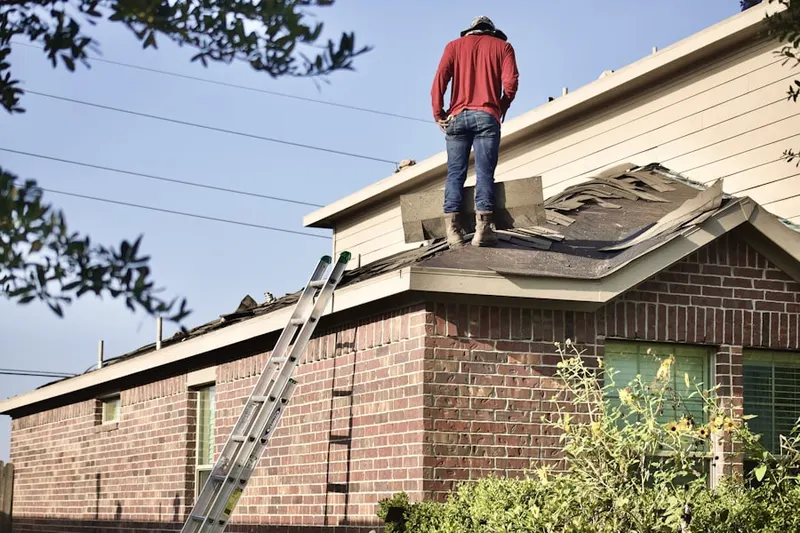 Professional roofer working on a residential roof in La Feria